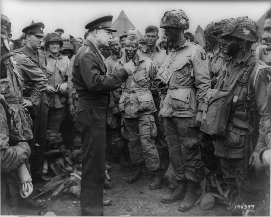 Gen. Eisenhower speaking with 1st Lt. Wallace C. Strobel and men of Company E 502nd PIR on June 5. The placard around Strobel's neck indicates he is the jumpmaster for chalk 23.